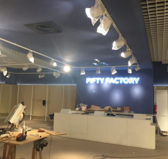 Tienda Fifty Factory en proceso de montaje con iluminación y mobiliario